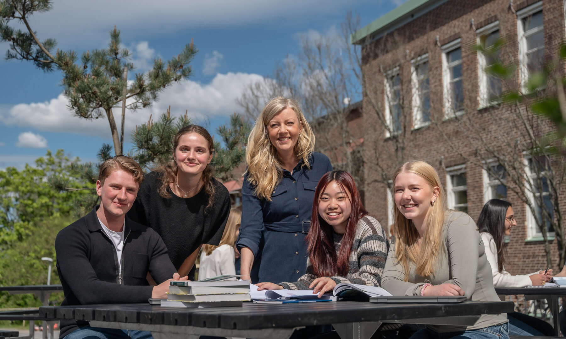Glada elever och en lärare pluggar i solen på Donner.