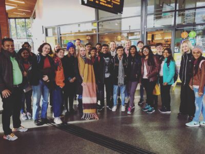 Gruppbild av svenska och indiska utbyteselever som ler tillsammans på en station