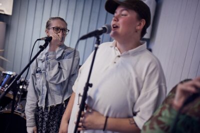 Två elever sjunger i mikrofoner under en musiklektion