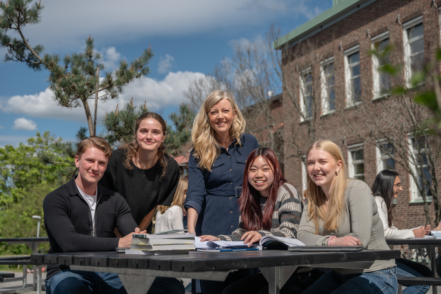 Glada elever och en lärare pluggar i solen på Donner.