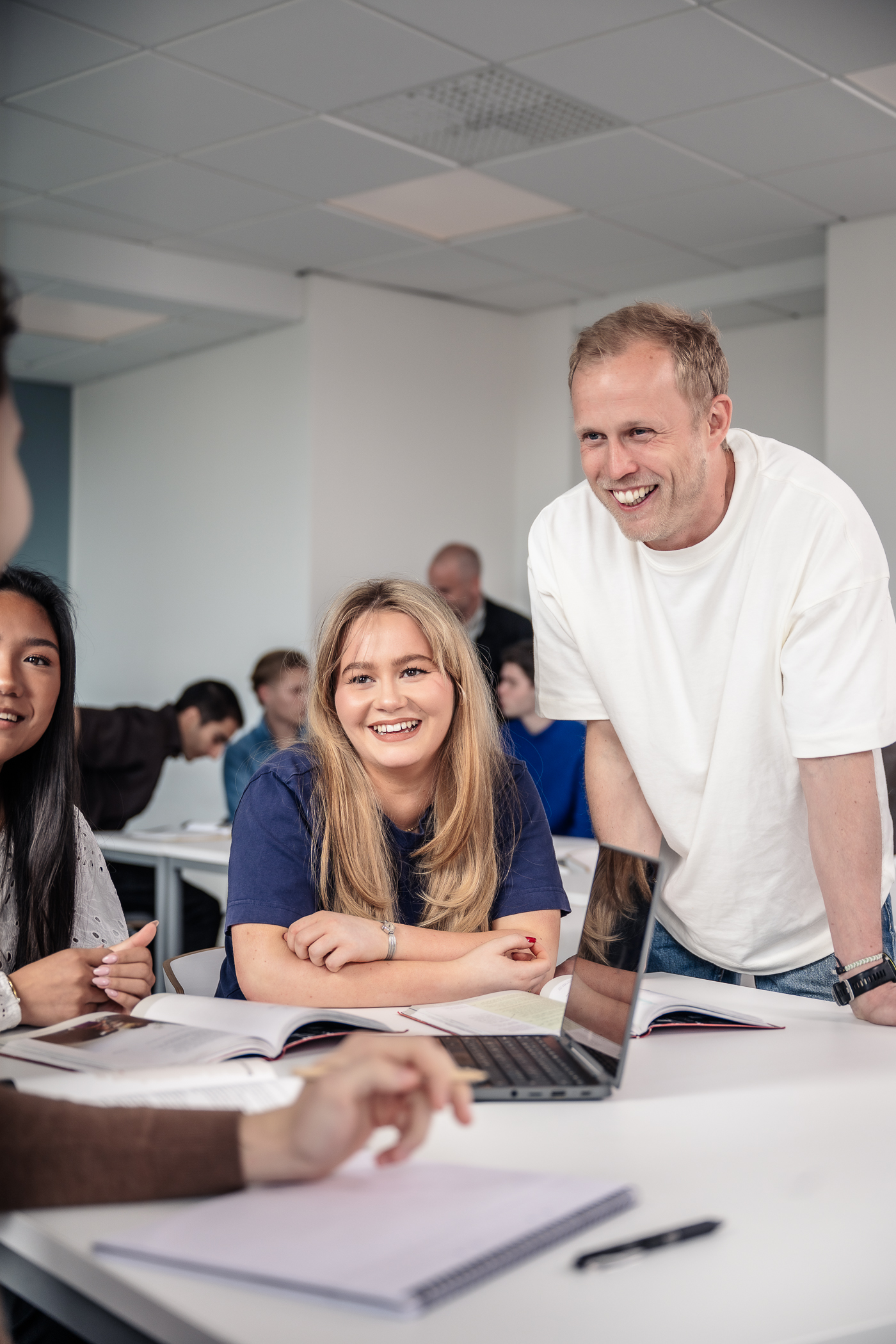 Elever och lärare löser en uppgift tillsammans och skrattar.