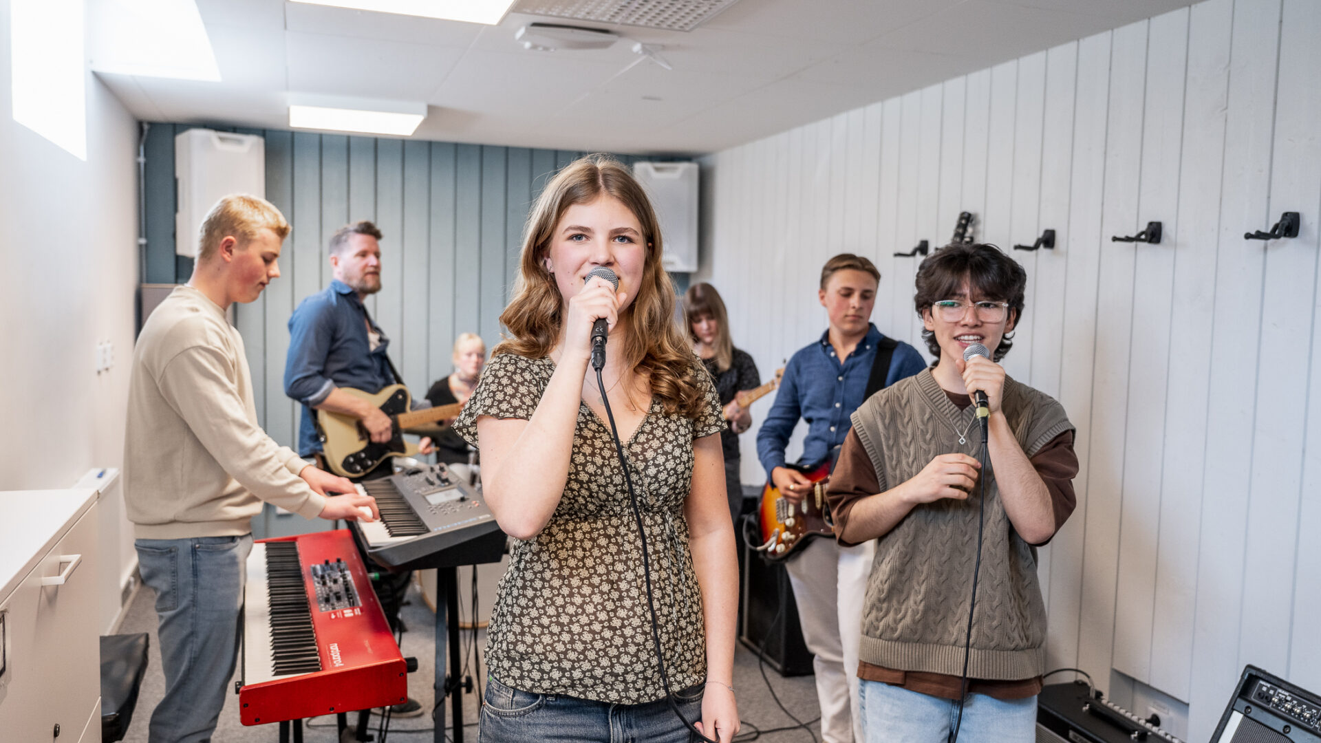 Musikelever sjunger och spelar i studion.